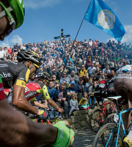 Cyclists race past a crowd on the Muur van Geraardsbergen, a cobblestone road in Belgium, during the 2017 Tour of Flanders.