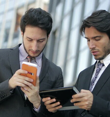 two guys working on their smartphones