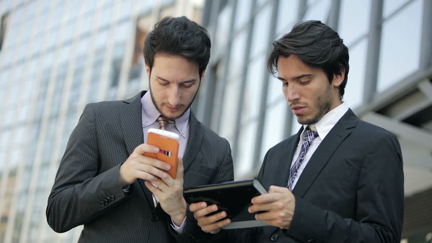 two guys working on their smartphones