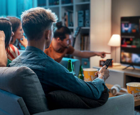 Friends choosing a movie to watch together at home, video on demand concept